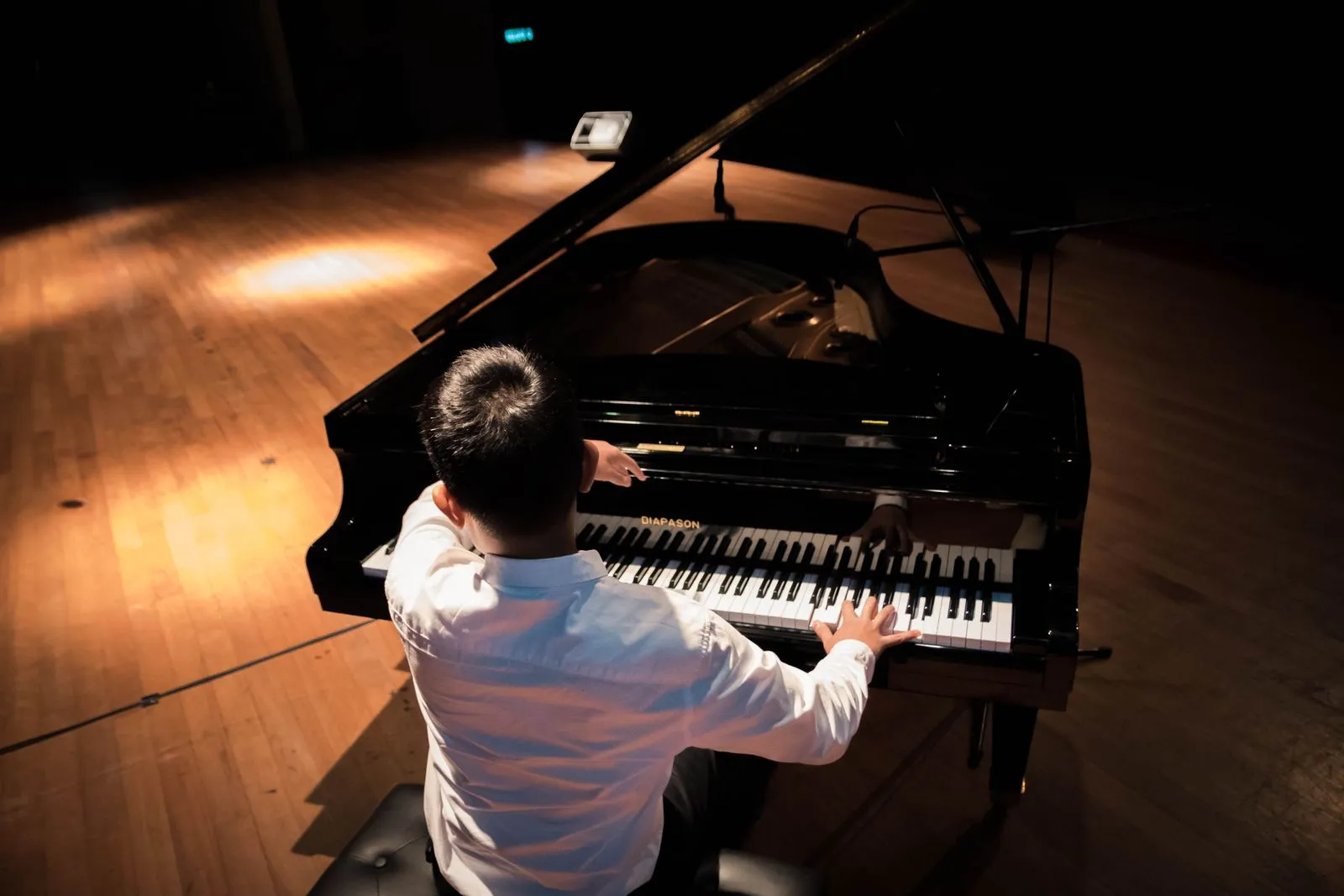 Nghệ sĩ chơi đàn grand piano trong không gian hòa nhạc